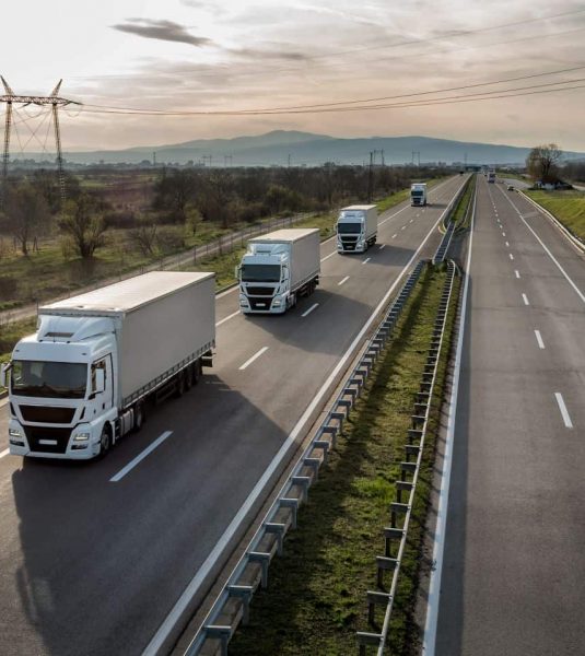 Caravan or convoy of trucks in line on a country highway