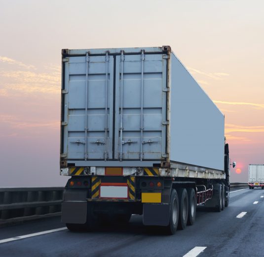 Truck on highway road with container, transportation concept.,import,export logistic industrial Transporting Land transport on the asphalt expressway with sunrise sk